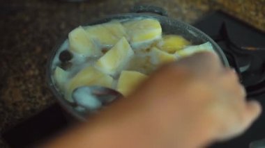 Bir tencerede sıcak suda pişirilmiş altın patatesler.