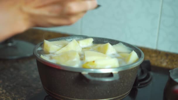 Bir tencerede sıcak suda pişirilmiş altın patatesler. — Stok video