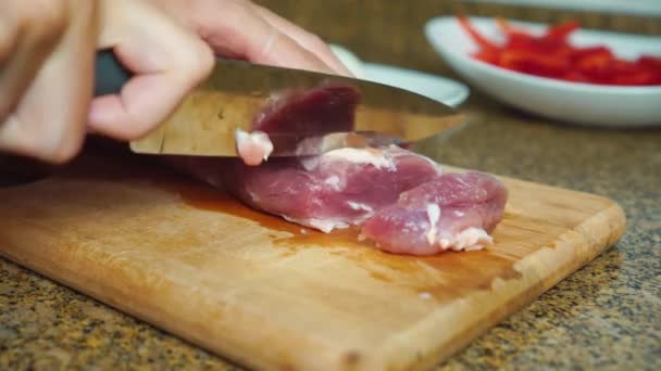 As mãos femininas estão cortando pedaço de carne vermelha na tábua de corte contra — Vídeo de Stock