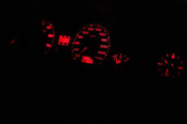 Hız göstergesi olan bir arabanın ön paneline yakın çekim, kırmızı arka ışıklandırmalı yakıt seviyesi