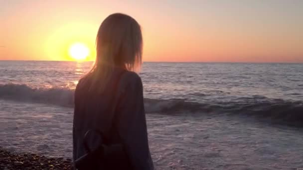 Chica está junto al mar y los sueños. Caminata romántica a lo largo de hermosa orilla. olas mar. — Vídeos de Stock