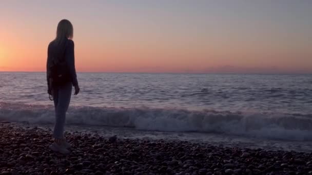 Ragazza si trova vicino al mare e sogni. Passeggiata romantica lungo la bellissima riva. onde mare. — Video Stock