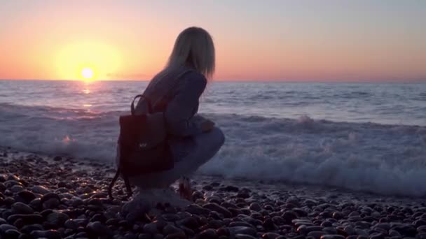 Chica está sentada junto al mar y soñando. Romántico paseo a lo largo de hermosa orilla. — Vídeos de Stock