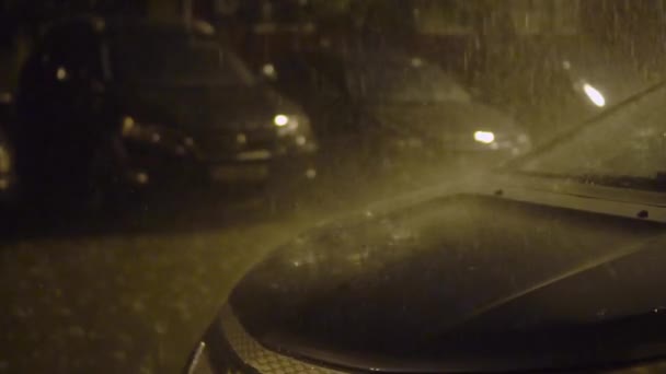 Автомобілі припарковані поспіль у дворі будинку. Буває сильний дощ, блискавка. — стокове відео