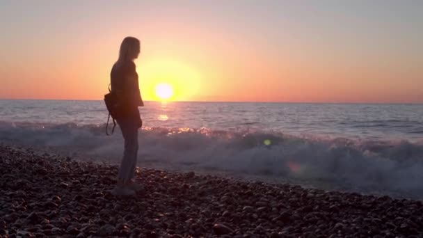 Dívka stojí u moře a snů. Romantická procházka podél krásného pobřeží. vlny moře. — Stock video