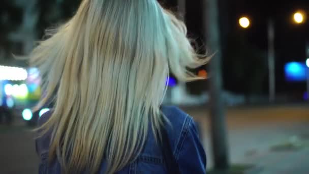 街の中心部を歩くデニムジャケットの若いスタイリッシュな女性のリアビュー — ストック動画