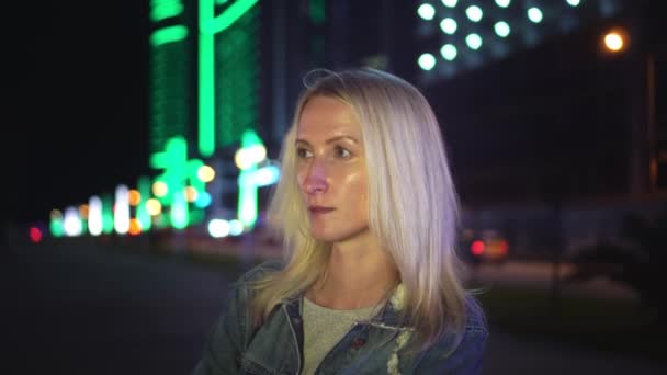 Portrait of a beautiful stylish blonde smiling at the camera. night city — Stock Video