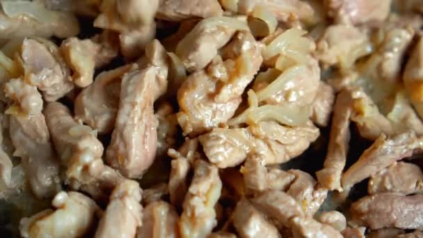 Kawałki mięsa wieprzowego z posiekaną cebulą podczas smażenia na starej patelni — Wideo stockowe