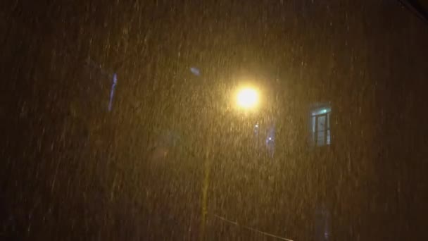 Erősen esik az eső a ház udvarán. Éjszaka van. erős vihar sújtotta város. — Stock videók