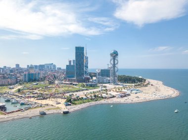 Batumi, Georgia - 20 Eylül 2021: Güneşli bir günde denizden dönme dolaba, alfabe kulesine, gökdelenlere, plaja, deniz kenarına insansız hava aracının görüntüsü