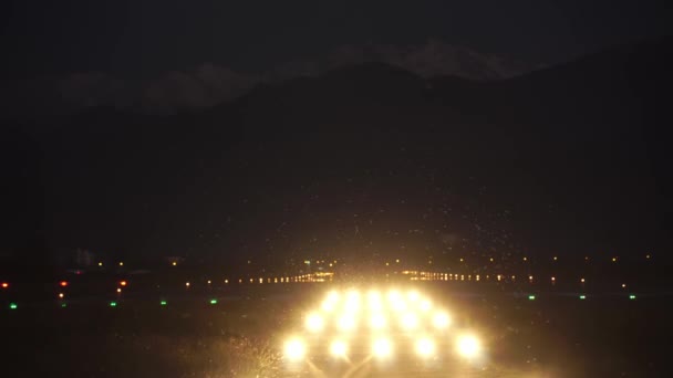 Het vliegtuig nadert en landt 's nachts in het donker op het vliegveld — Stockvideo
