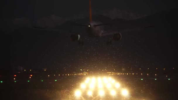 El avión se acerca y aterriza en la oscuridad por la noche en el aeropuerto — Vídeo de stock