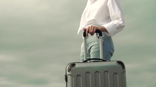 Μια όμορφη γυναίκα με μια βαλίτσα στο φόντο της θάλασσας — Αρχείο Βίντεο