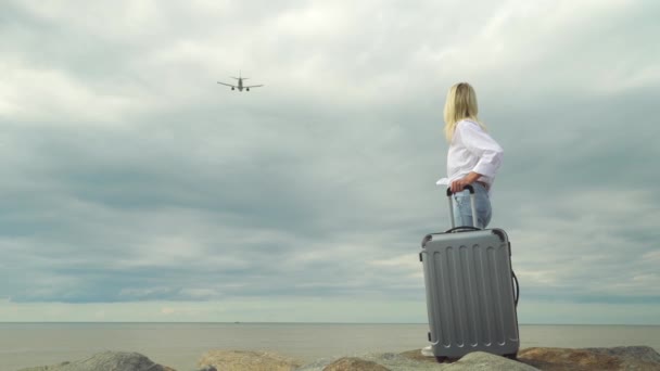 一个漂亮的女人，背对着大海，提着手提箱 — 图库视频影像