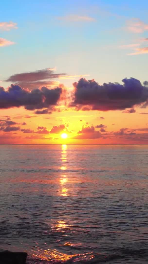 En ljus orange solnedgång i molnen på havet. — Stockvideo