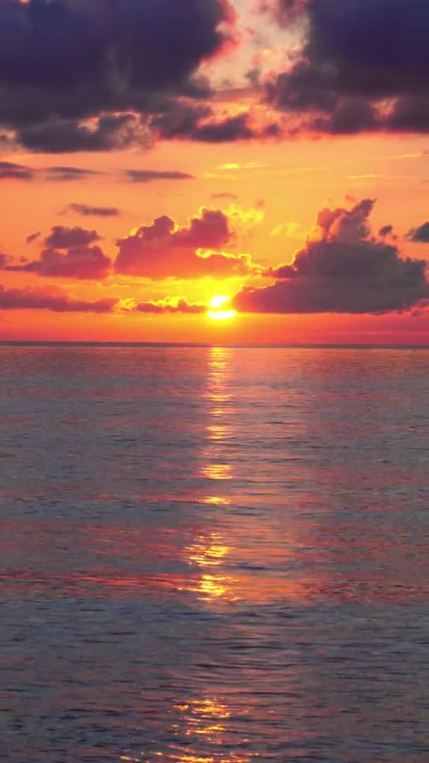 Denizdeki bulutlarda parlak turuncu bir günbatımı. — Stok video