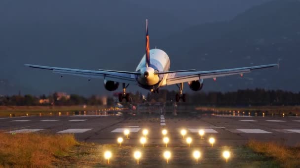 Letadlo přiletí a přistane časně ráno na letišti ve večerních hodinách — Stock video