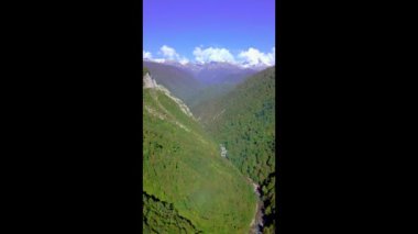Yılanımsı dağ yolu ve ormanla sonbahar dağlarının üzerinden Drone 'la uçmak.