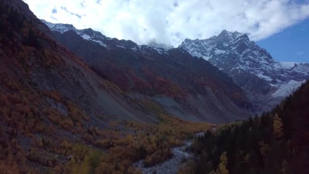 Dron vuela sobre el río entre montañas en otoño, en la distancia Glaciar Chalaadi — Vídeos de Stock