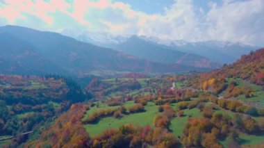 Yılanımsı dağ yolu ve ormanla sonbahar dağlarının üzerinden Drone 'la uçmak.