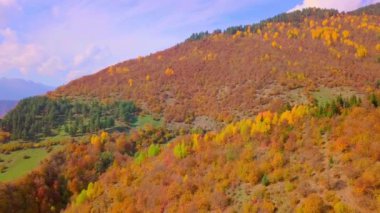 Sonbaharda, sonbaharda, günbatımında, renkli sonbaharda, dağların üzerinden destansı bir hava aracı uçuşu.