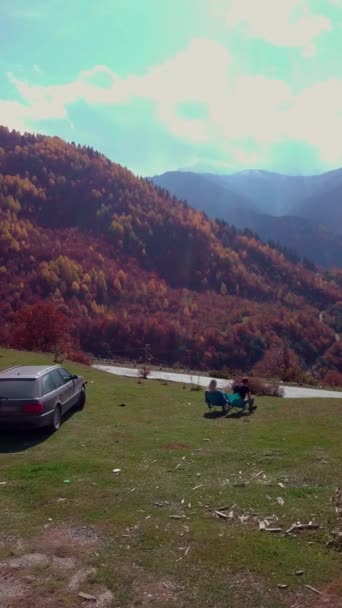 Jovem casal de um cara e uma menina almoçar com vista para as montanhas. — Vídeo de Stock