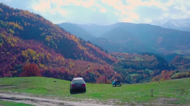 Junges Paar aus einem Mann und einem Mädchen essen zu Mittag mit Blick auf die Berge. — Stockvideo