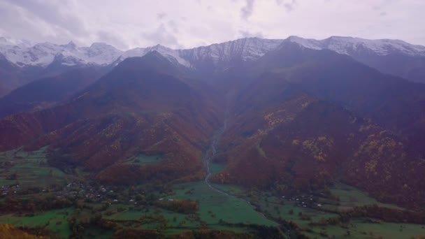 Вид снизу на деревню с высоты птичьего полета, у подножия горы, дом в устье реки. — стоковое видео
