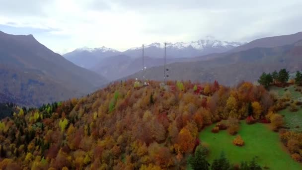 Drohnen fliegen in einer bergigen Gegend. Auf dem Gipfel des Berges erhebt sich der GSM-Turm. Herbst. — Stockvideo