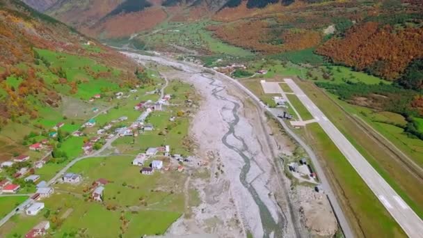 Вид с высоты птичьего полета на небольшой аэропорт в центре горной деревни. — стоковое видео