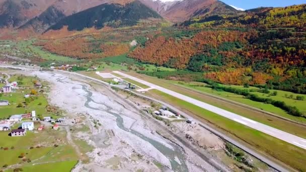 Una vista de pájaro de un pequeño aeropuerto en medio de un pueblo de montaña. — Vídeos de Stock