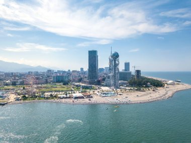 Batumi, Georgia - 20 Eylül 2021: Güneşli bir günde denizden dönme dolaba, alfabe kulesine, gökdelenlere, plaja, deniz kenarına insansız hava aracının görüntüsü