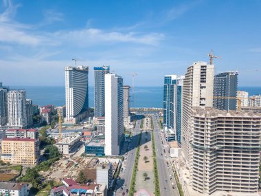 Batum 'da inşaat halindeki gökdelenlerin insansız hava aracı görüntüsü, deniz, güneşli bir günde bulvar.