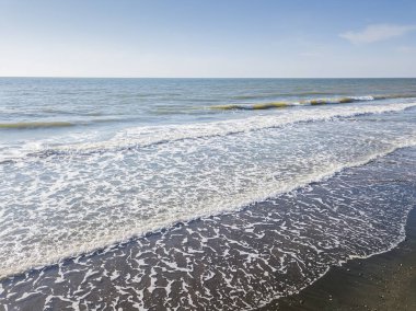 Güneşli bir günde büyük dalgalarla denizin kumlu sahilinin drone görüntüsü