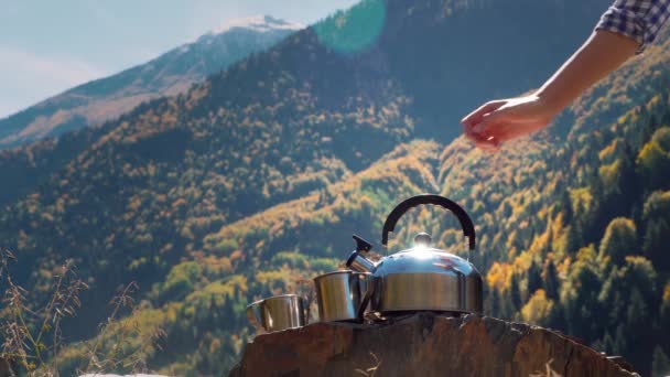 Путешественница наливает горячую воду из чайника в металлическую кружку крупным планом, — стоковое видео