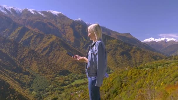 美しいブロンドは秋の山の風景の写真やビデオを撮る. — ストック動画