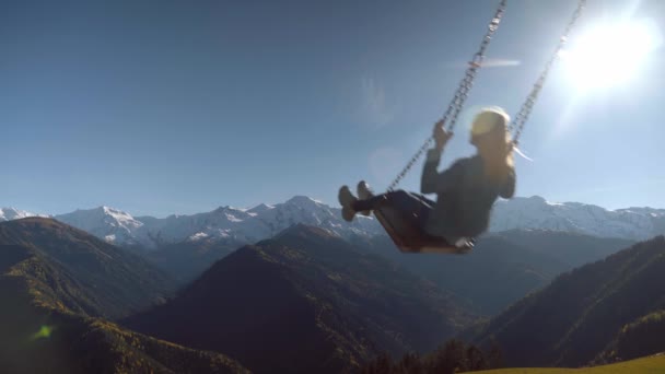 Femme balade sur une grande balançoire sur fond de montagnes en Géorgie, — Video