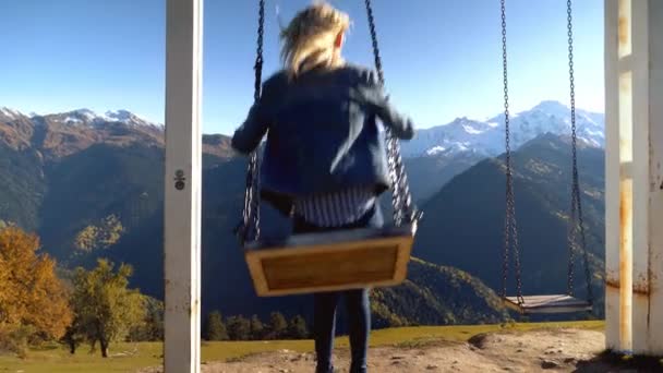 Vrouw rijdt op grote schommel tegen de achtergrond van bergen in Georgië, — Stockvideo