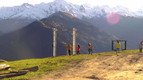 Vista de los turistas balanceándose en un columpio con vistas a las montañas. — Vídeo de stock