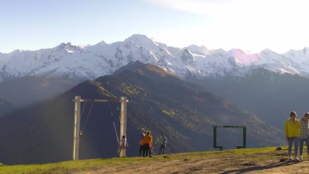 Blick auf Touristen, die auf einer Schaukel mit Blick auf die Berge schwingen. — Stockvideo