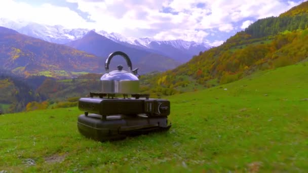 Vattenkokare finns på en portabel campinggasspis, vatten värms upp, bergen — Stockvideo