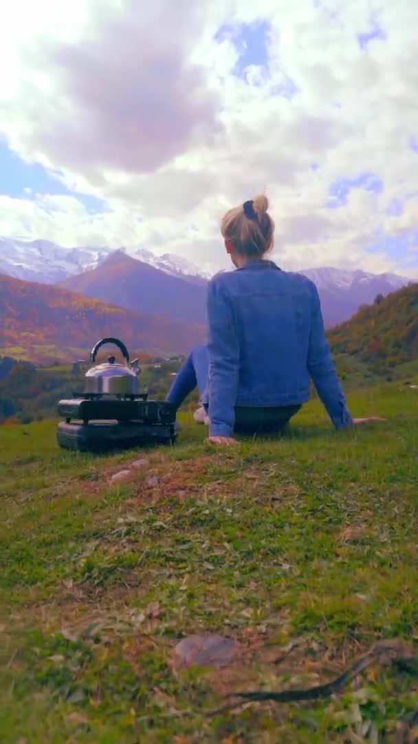Una mujer admira las montañas, una tetera está hirviendo. Georgia. — Vídeo de stock