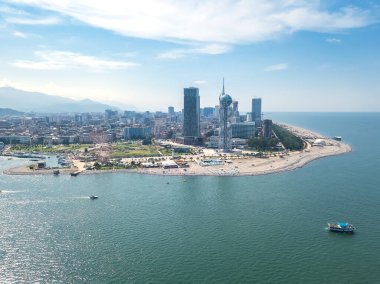 Batumi, Georgia - 20 Eylül 2021: Güneşli bir günde denizden dönme dolaba, alfabe kulesine, gökdelenlere, plaja, deniz kenarına insansız hava aracının görüntüsü