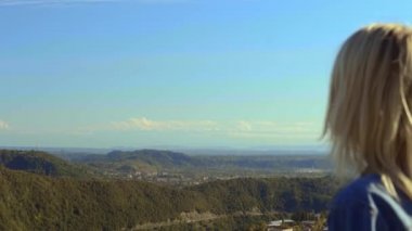 özgür, mutlu kadın gezgin kot ceketli, dağlara bakıyor.