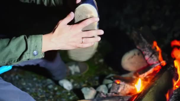 Человек приклеивает старый порванный кроссовок к огню. Руки человека в крупном плане. — стоковое видео