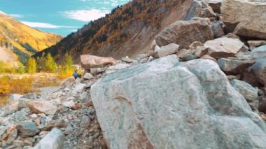 Genç turist dağlık alanda yürüyor ve güzel manzaralara bakıyor..