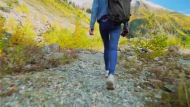 Genç turist dağlık alanda yürüyor ve güzel manzaralara bakıyor..