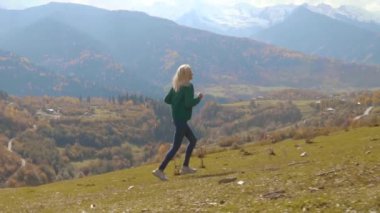 Kamera yokuş aşağı koşan genç ve güzel bir kadını takip ediyor.