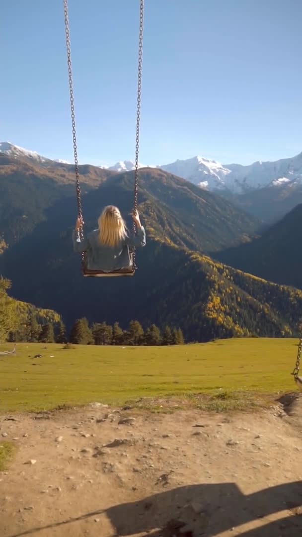 Woman rides on large swing against background of mountains in Georgia, — Stock Video