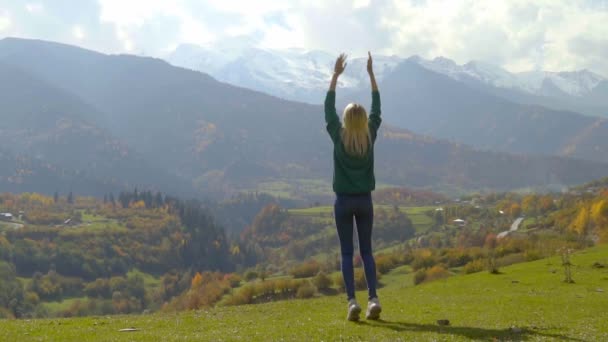 Frau springt und klatscht in die Hände vor dem Hintergrund der Berge — Stockvideo